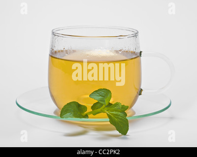 a cup with peppermint tea, beside are Peppermint leaves Stock Photo