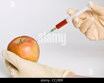 genetic engineering, a liquid is injected into an apple. Stock Photo