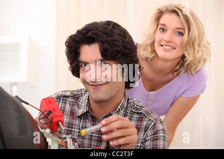 Couple repairing old television Stock Photo
