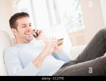 USA, New Jersey, Jersey City, Man talking on mobile and holding credit card Stock Photo