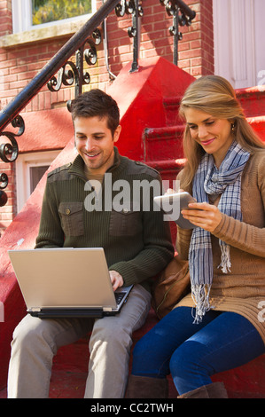 USA, New Jersey, Jersey City, Young couple sitting with take-away coffee Stock Photo