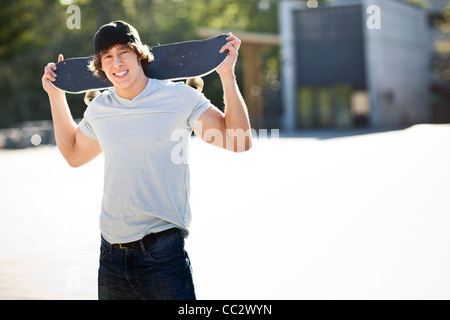 USA, Washington, Seattle, young man posing with skateboard Stock Photo