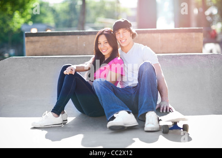 USA, Washington, Seattle, Young multi-racial couple posing with skateboard Stock Photo