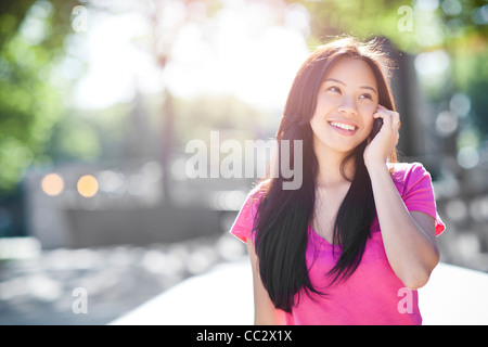 USA, Washington, Seattle, Young chinese woman using mobile phone outdoors Stock Photo
