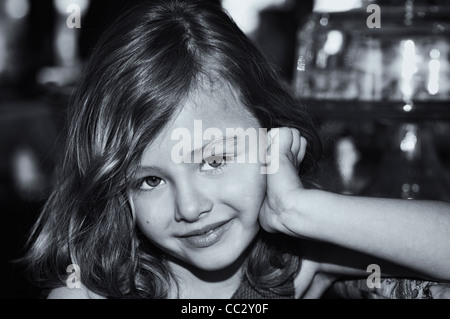 Cute portrait of a young 5 year old brunette girl smiling with big brown eyes gazing into the camera. Amyn Nasser Stock Photo