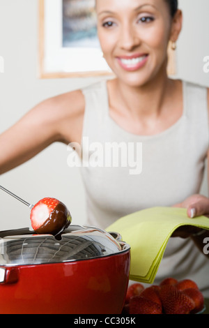 USA, California, Los Angeles, Woman dipping strawberries in chocolate mousse Stock Photo