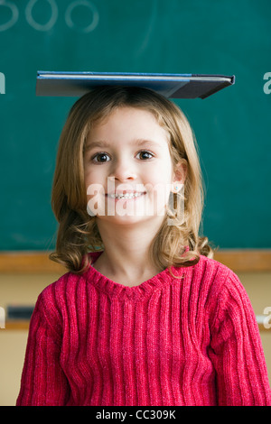 USA, California, Los Angeles, Portrait of girl (6-7) balancing book on head Stock Photo