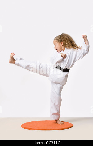 Girl (8-9) training martial arts, studio shot Stock Photo