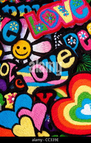 Embroidery iron on patches of Multicoloured Love, Peace, Happy words with hearts on a black background Stock Photo