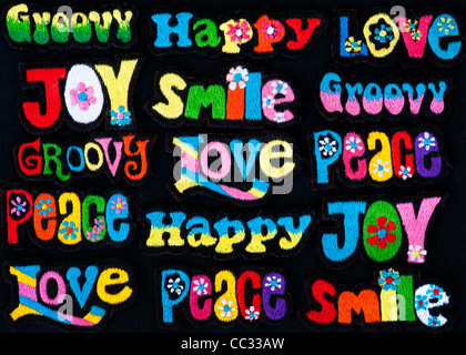 Embroidery iron on patches of Multicoloured Love, Peace, Happy, Smile, Joy and Groovy words on a black background Stock Photo