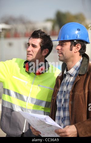 Architect and foreman looking at plans Stock Photo