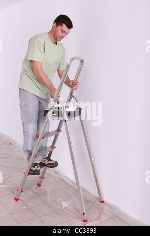 Man painting on a ladder Stock Photo