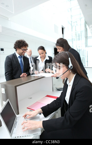Female receptionist using a headset and laptop computer Stock Photo