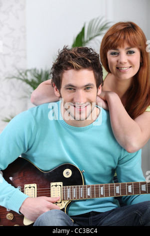 a man playing guitar and his girlfriend Stock Photo