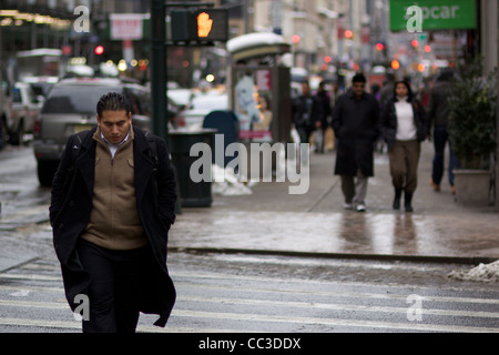 Man crossing city street in the winter. Stock Photo