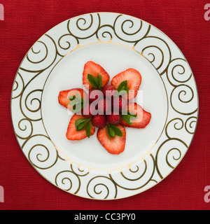 English strawberries, raspberries and refreshing mint arranged on a plate. Stock Photo