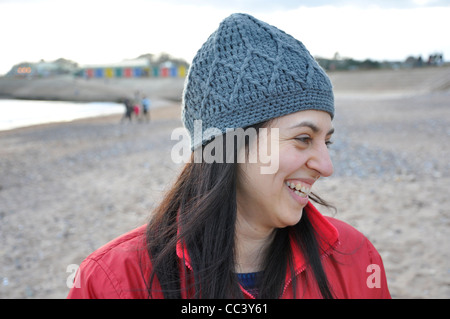 Woman laughing walking on a beach during winter time. Stock Photo