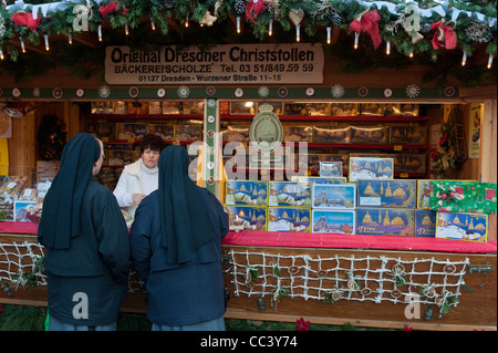 Two nuns at a Christmas Stollen cake stall. Stietzelmarkt Christmas market in Dresden. Saxony, Germany, Europe Stock Photo