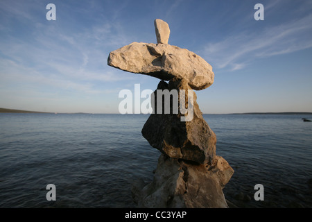Cross, rocks stacked one one top of another on beach Stock Photo