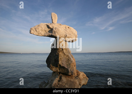 Cross, rocks stacked one one top of another on beach Stock Photo