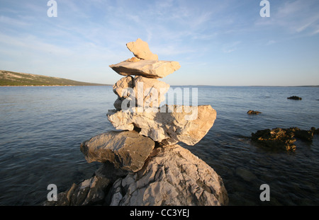 Cross, rocks stacked one one top of another on beach Stock Photo
