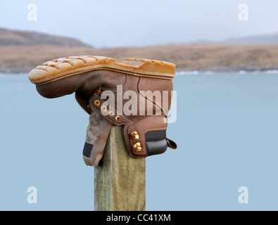 shoe on a wooden stack and blurry scottish landscape in the back Stock Photo