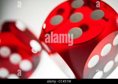 A close-up shot of red game dice rolling with light reflecting through Stock Photo