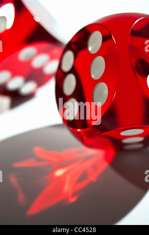 A close-up shot of red game dice rolling with light reflecting through Stock Photo