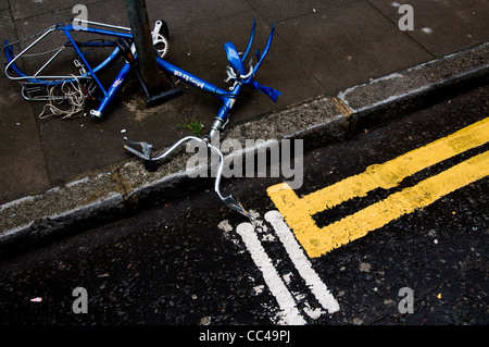 Broken and vandalised bicycle abandoned on the street in London Stock Photo