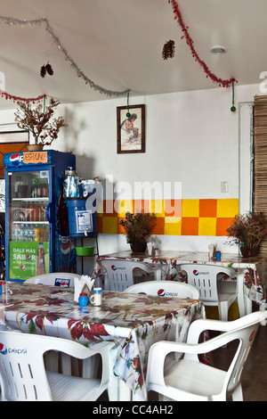 colorful brightly colored light filled interior of modest cafe restaurant decorated for Christmas Oaxaca Mexico Stock Photo