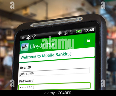 Logging on to mobile internet banking with the Lloyds TSB app on an HTC smartphone Stock Photo