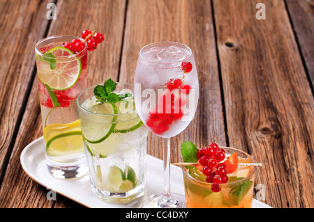 Glasses of iced drinks garnished with fresh fruit Stock Photo