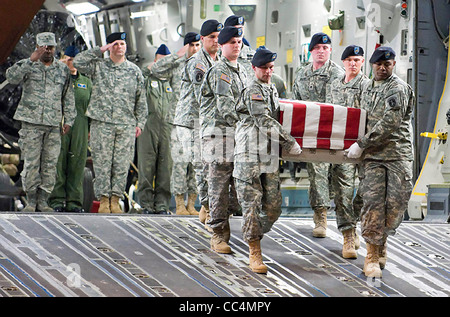 US military personnel salute a transfer case as an Army carry team transfers remains April 24, 2009 Dover Air Force Base, DE. Defense Secretary Robert M. Gates lifted the ban on filming the transfer ceremony. Stock Photo