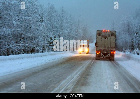 40,524.02069 winter 18 wheelers trucks night snowstorm slick snow covered 2-lane rural mountain road chains snowing hazardous dangerous travel Stock Photo