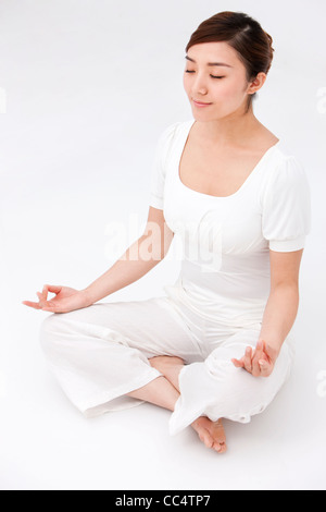 Young woman sitting and meditating Stock Photo