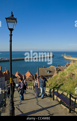 People tourists visitors walking up the 199 steps and view to the harbour Whitby North Yorkshire England UK United Kingdom GB Great Britain Stock Photo