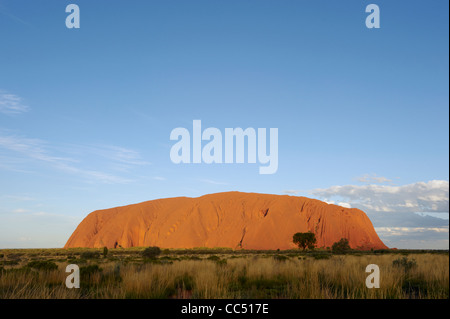 Sunset on Uluru; Ayers Rock glows orange under the setting sun, Uluru-Kata Tjuta National Park, Northern Territory, Australia Stock Photo