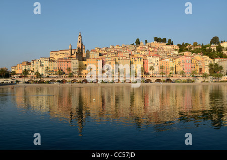 Sunrise over the Historic District or Old Town of Menton Reflected in Mediterranean Sea Alpes-Maritimes France Stock Photo