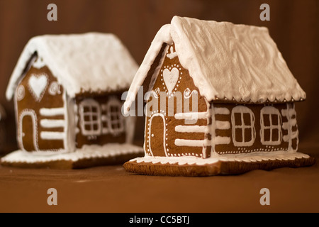 Two gingerbread cottages decorated in the fashion of snow-covered old wooden houses/log cabin typical for Central Europe Stock Photo