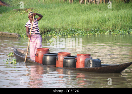 Woman poling boat on Lac Nokoue near Ganvie stilt village, Benin, West Africa Stock Photo
