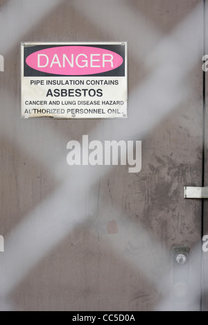 Asbestos warning sign posted on door to abandoned factory building, North Carolina, USA Stock Photo