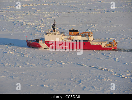 The 420-foot Coast Guard Cutter Healy breaks ice in the Bering Sea to assist the tanker Renda get to fuel starved Nome, Alaska January 8, 2012 in the Bering Sea. The Seattle-based cutter Healy is the Coast Guard’s newest and most technologically advanced polar icebreaker and is currently the United Stock Photo