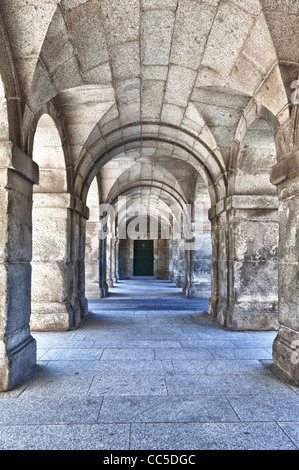 Strong marble arches with a green door at the end of the tunnel, image with a lot of texture. Stock Photo