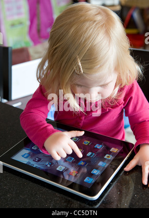 Caucasian toddler uses Apple iPad applications to entertain herself and learn Stock Photo