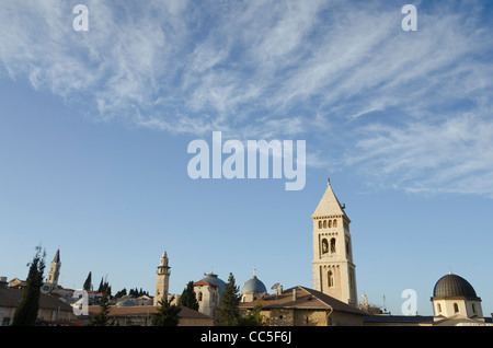 view of church tops and minaret with clear sky and light clouds in bkgd. Jerusalem Old City. israel Stock Photo
