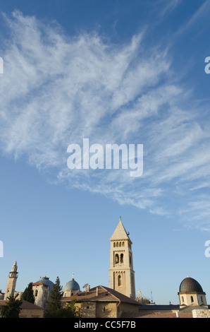 view of church tops and minaret with clear sky and light clouds in bkgd. Jerusalem Old City. israel Stock Photo