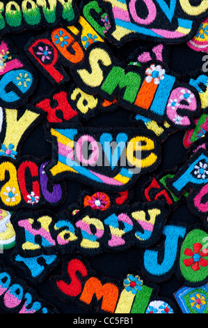 Embroidery iron on patches of Multicoloured Love, Peace, Happy, Smile, Joy and Groovy words on a black background Stock Photo