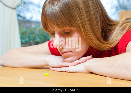 Woman with tablet. Deciding whether to take tablet. Stock Photo