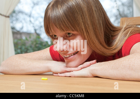 Woman with tablet. Deciding whether to take tablet. Stock Photo