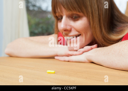 Woman with tablet. Deciding whether to take tablet. Stock Photo